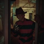 Cosplayer in image of Freddy Krueger from Nightmare on Elm Street film stands in dark