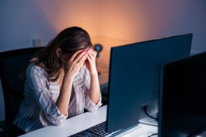 Stressed out woman working late in an office