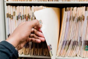 Medical records, charts, African American man sorting through patient charts